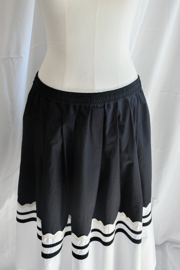 SS25_075-F-rubino-gaeta-gonna-pieghe-neropanna-passamanerie-04